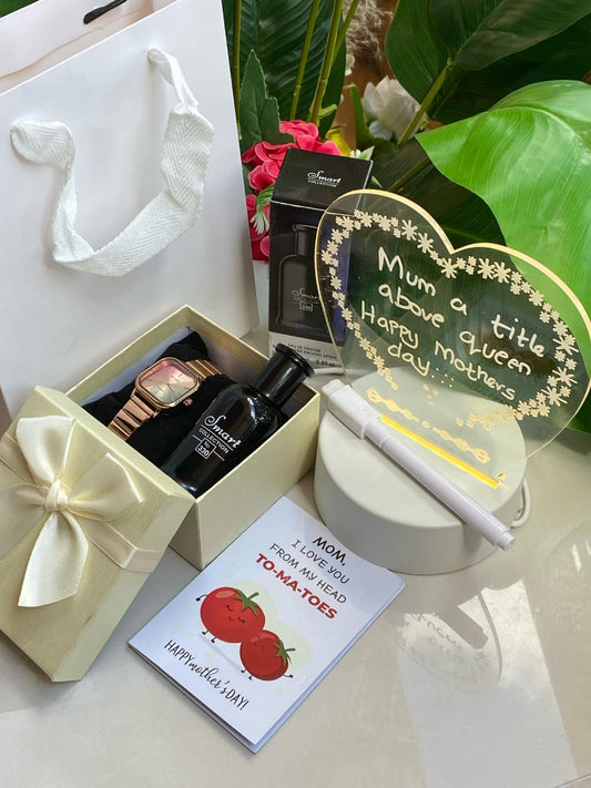 Mother's Day gift set with a rose gold watch, small black perfume bottle, and heart-shaped light-up message board with a pen, presented in a gift box and bag.