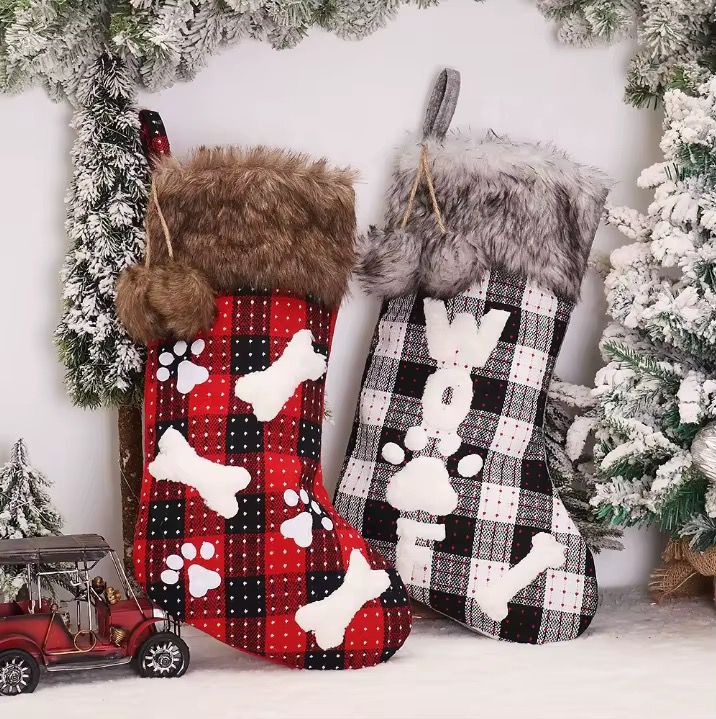Two Christmas stockings with plaid patterns and paw print designs, 