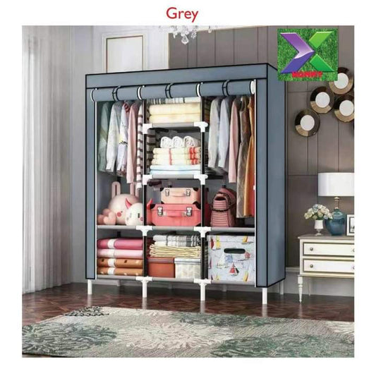 A fully assembled, three column grey fabric portable wardrobe standing in a modern room