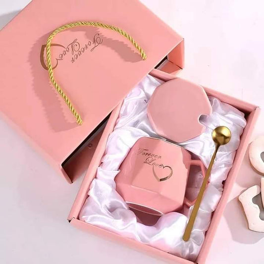 A diamond shaped ceramic coffee mug with a crown design, matching lid, and spoon, all packaged inside an exquisite gift box.